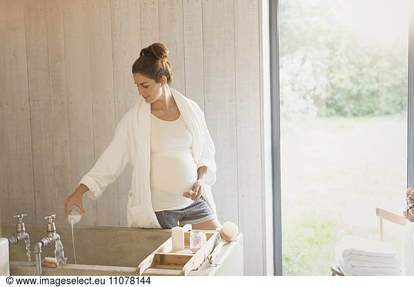 Pregnant woman preparing bubble bath