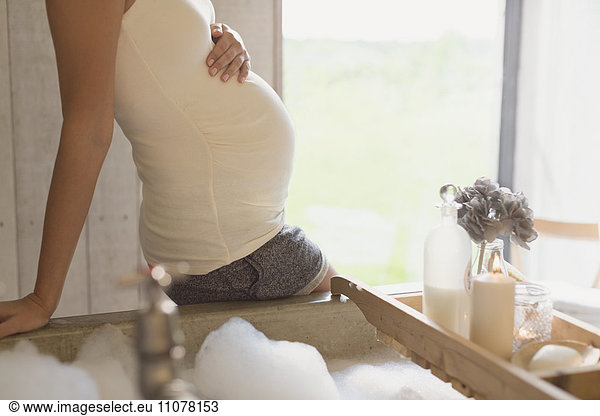 Pregnant woman preparing bubble bath