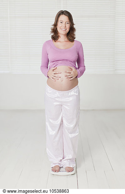 Pregnant woman weighing herself