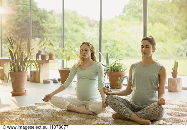Pregnant women meditating in lotus position