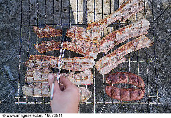 preparation of barbecue on bacon and sausage grill