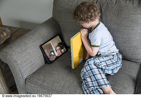 Preschool Boy Reads Book With Grandma Over Video Chat