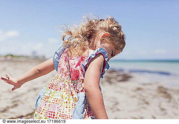 Preschooler girl playing on the beach.