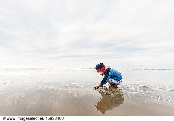 Preschooler playing at beach in winter
