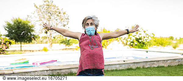 pretty white haired senior woman with face mask by covid-19  jumping happy