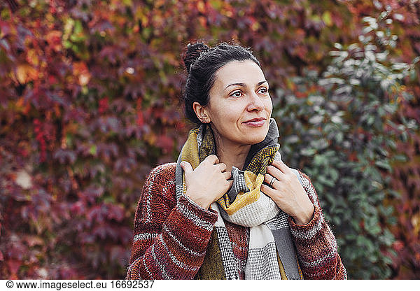 Pretty woman in scarf and sweater  autumn park  red leaves