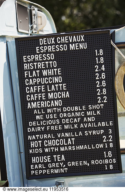 Price list for hot drinks on a blue mobile coffee shop.