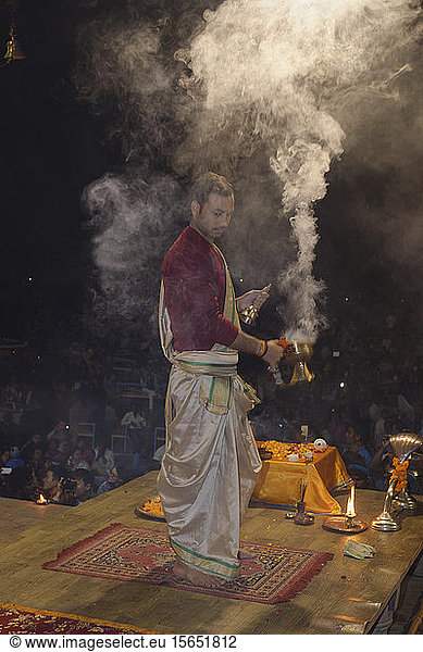 Priest celebrating the River Ganges  Aarti by offering incense  Dashashwamedh Ghat  Varanasi  Uttar Pradesh  India  Asia