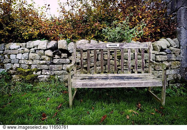 Primer plano de un banco de madera de jardín con el cartel de 'PRIVADO' Litton  Yorkshire Dales  North Yorkshire  Skipton  UK.
