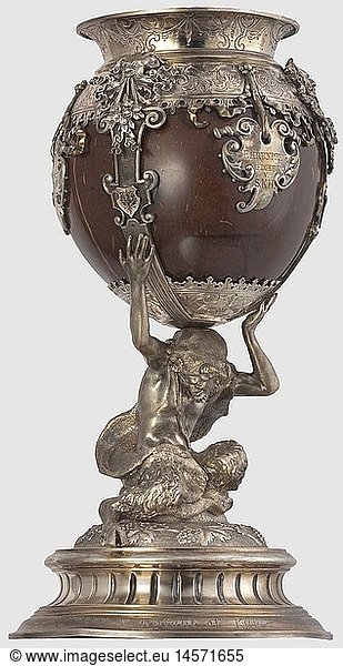 Prince Ludwig Ferdinand of Bavaria (1859 - 1949)  a silver-mounted coconut goblet  Munich 1883 Polished coconut held by three clasps with embossed flower ornaments at the border and applied grotesque masks. With three cartouches shaped like coats-of-arms bearing the engraved inscription (tr.) 'Prize awarded by H.R.H. - Prince Ludwig Ferdinand of Bavaria - Munich 1883'. Shaft in the form of a faun wearing a lion's hide. Fluted base  the top decorated with embossed vine leaves  the inside with maker's mark (tr.) 'Art Studio Carl Haymann Jeweller Munich'. The rim of the base with engraving of later date (probably by an American soldier) reading 'Condor v. Knight of Kars'. Height 25.6 cm  weight 1100 g  historic  historical  19th century  Bavaria  Bavarian  German  Germany  Southern Germany  the South of Germany  Royal  object  objects  stills  clipping  cut out  cut-out  cut-outs