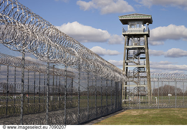 Prison fence  watch tower and barbed wire at a Correctional Facility. High security fencing.