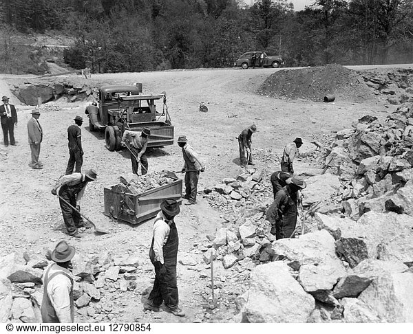 PRISONERS. African American convicts breaking up rocks for road construction at a prison camp in rural America. Photograph  c1934-1950.