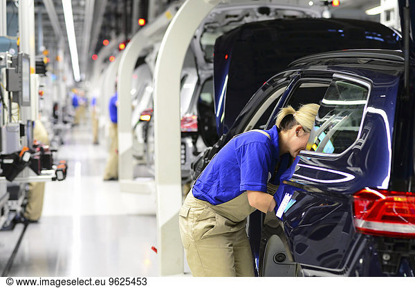 Production of VW cars in a factory  worker installing vehicle interior
