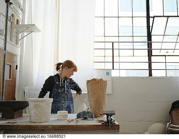 Professional female sculptor taking a break in her studio