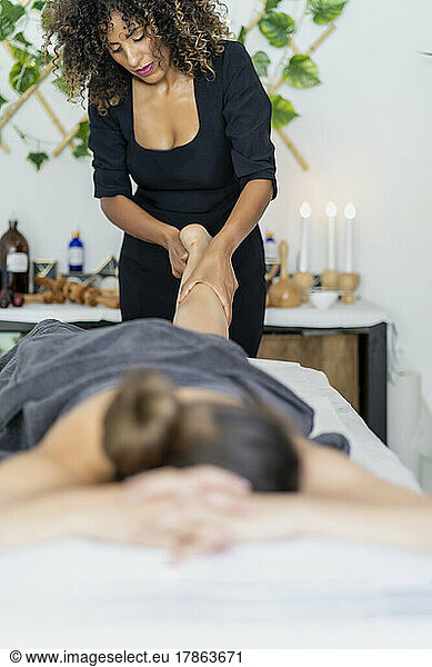professional masseur doing a relaxing leg massage