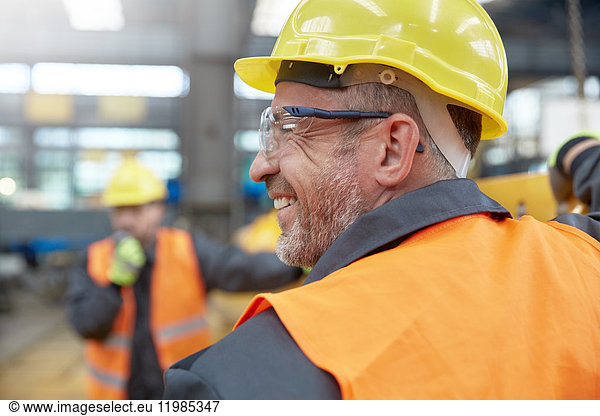 Profil lächelnder Arbeiter in der Fabrik