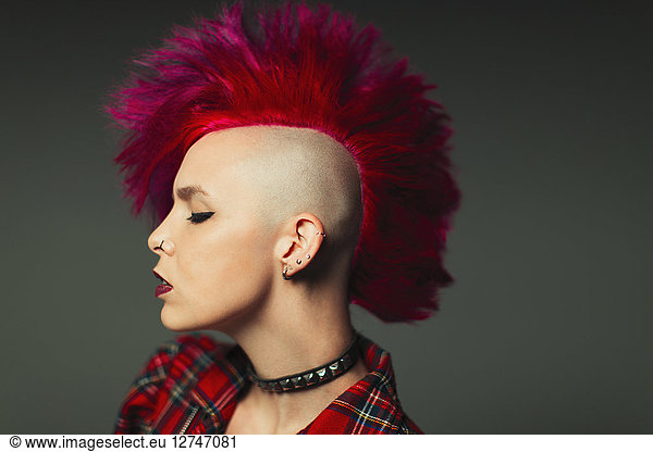 Profile portrait cool young woman with pink mohawk