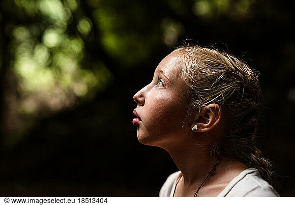 Profile portrait of tween girl looking up