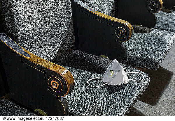 Protective face mask lying on seat in empty theater