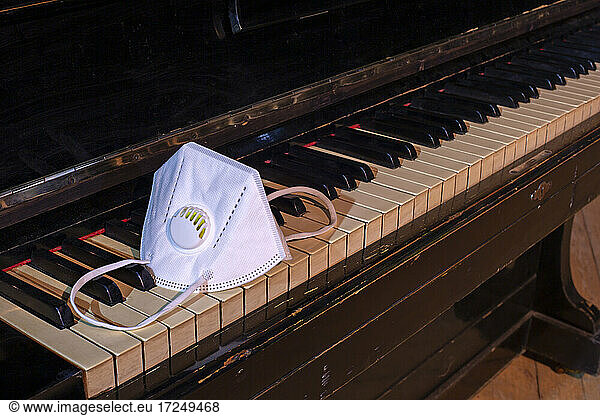 Protective face mask lying on top of piano keyboard