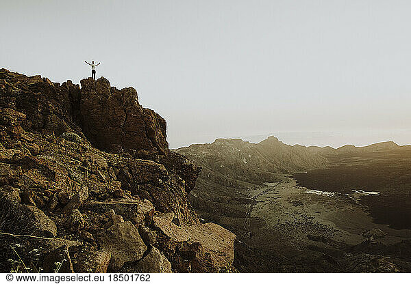 Pulled back of man standing on rock at mountain top in Mount Teide