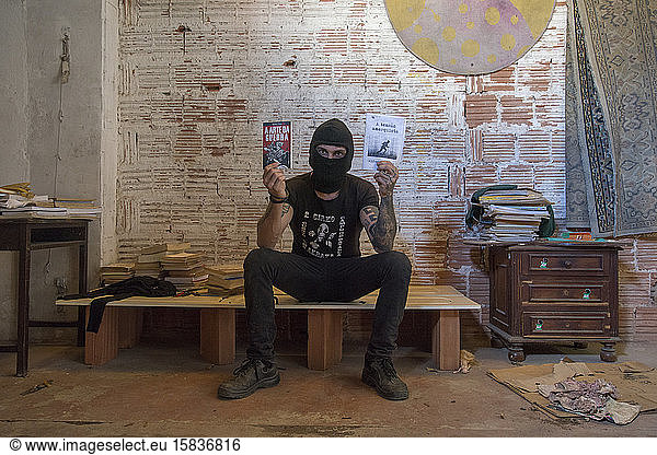 Punk activist on a trespassed property holding revolutionary books