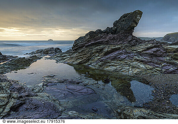 Purple coloured rocks on the Cornish shoreline at sunset  Polzeath  Cornwall  England  United Kingdom  Europe