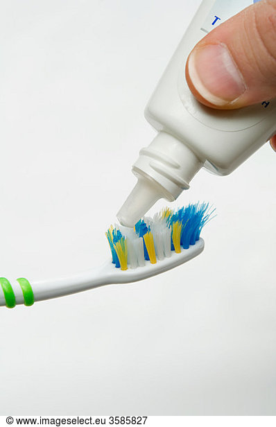 Putting toothpaste on toothbrush