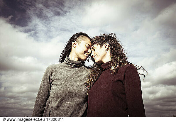 queer lesbian female couple connect heads in intimate moment in berlin