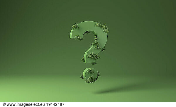 Question sign covered with green plants against green background