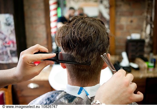 Rückansicht des jungen Mannes im Friseursalon mit Haarschnitt