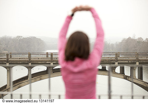 Rückansicht einer Frau beim Training an der Lamar Boulevard Bridge über den Lady Bird Lake gegen den Himmel