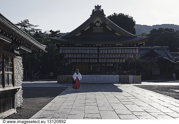 Rückansicht einer Frau  die auf Pflastersteinen am Heiligtum von Yasaka geht