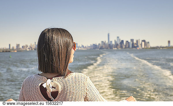 Rückansicht einer jungen Frau  die auf einem Ausflugsboot steht  New York City  USA