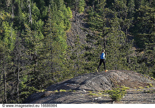 Rückansicht einer starken Sportlerin  die beim Fitnesstraining auf dem Lande einen Bergpfad entlangläuft