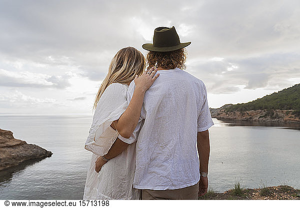 Rückansicht eines jungen Paares vor dem Meer mit Blick aufs Meer  Ibiza  Balearen  Spanien