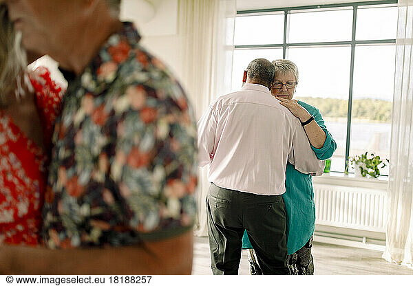 Rückansicht eines älteren Mannes  der mit einer Frau im Tanzkurs tanzt