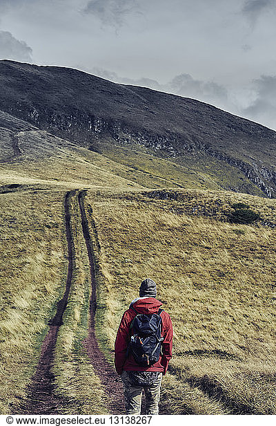 Rückansicht eines männlichen Wanderers mit Rucksack beim Wandern auf dem Balkan gegen den Himmel