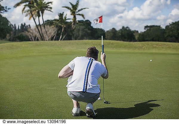 Rückansicht eines Mannes im Fokus auf einem Golfplatz