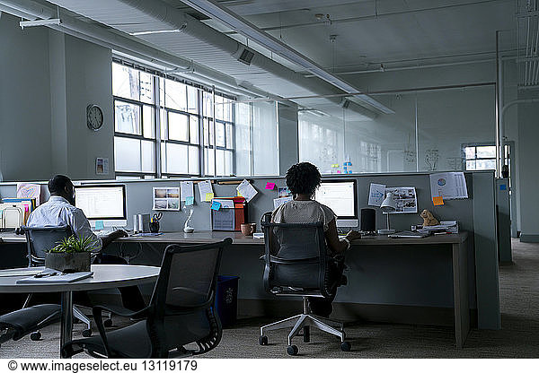 Rückansicht von Geschäftsleuten  die Desktop-Computer am Schreibtisch im Büro benutzen