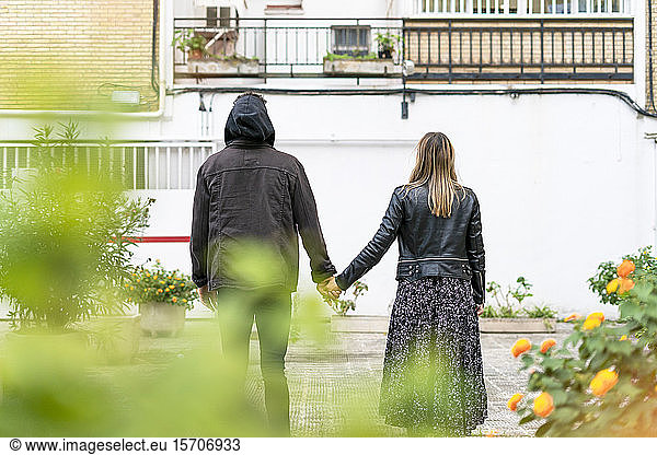 Rückenansicht eines jungen Paares Hand in Hand