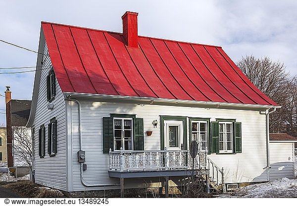 Rückseite eines alten Hauses im kanadischen Landhausstil aus dem Jahr 1835 aus weißem Holz mit grüner Verkleidung und rotem Blechdach im frühen Frühling  Quebec  Kanada  Nordamerika