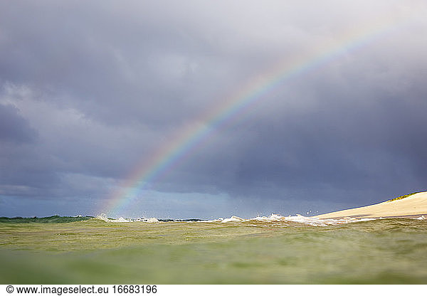 Rainbow in Hawaii going into the Ocean