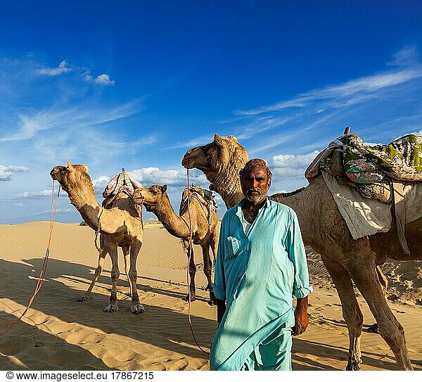 Rajasthan Reise-Hintergrund  indischer Mann cameleer (Kameltreiber) Porträt mit Kamelen in den Dünen der Wüste Thar. Jaisalmer  Rajasthan  Indien  Asien