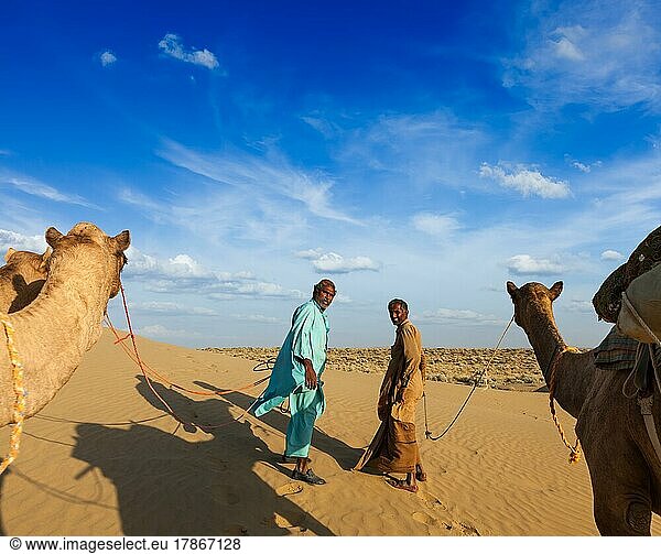 Rajasthan Reise-Hintergrund  zwei indische Kamele (Kameltreiber) mit Kamelen in den Dünen der Wüste Thar. Jaisalmer  Rajasthan  Indien  Asien