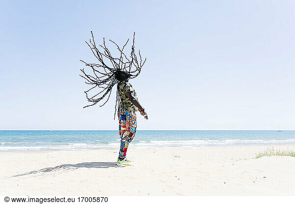 Rastafari-Mann  der seine Dreadlocks am Strand wirft