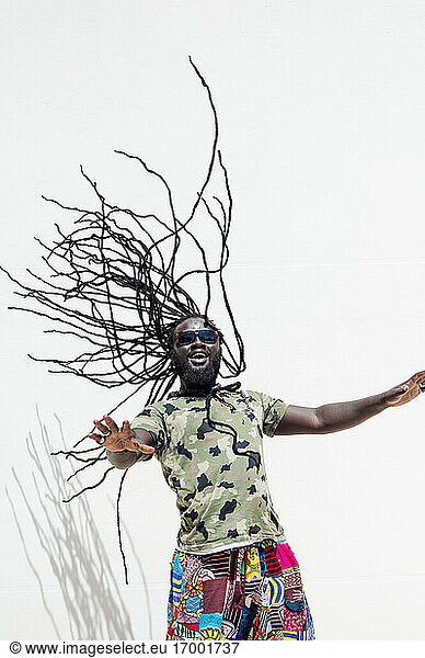Rastafari-Mann mit Sunglsass  der seine Dreadlocks schwingt