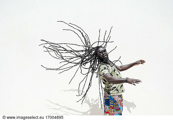 Rastafari-Mann mit Sunglsass  der seine Dreadlocks schwingt