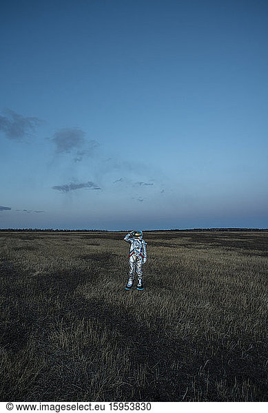 Raumfahrerin auf der Wiese am Abend
