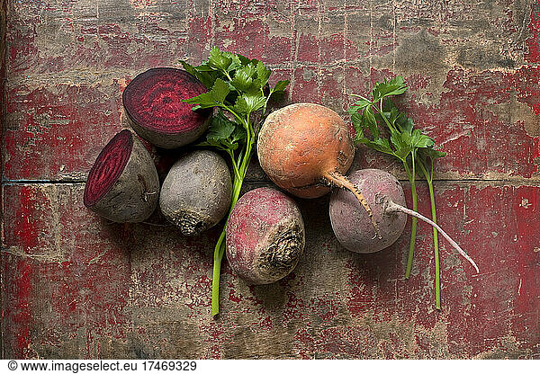 Raw beetroots and parsley on weathered wooden surface